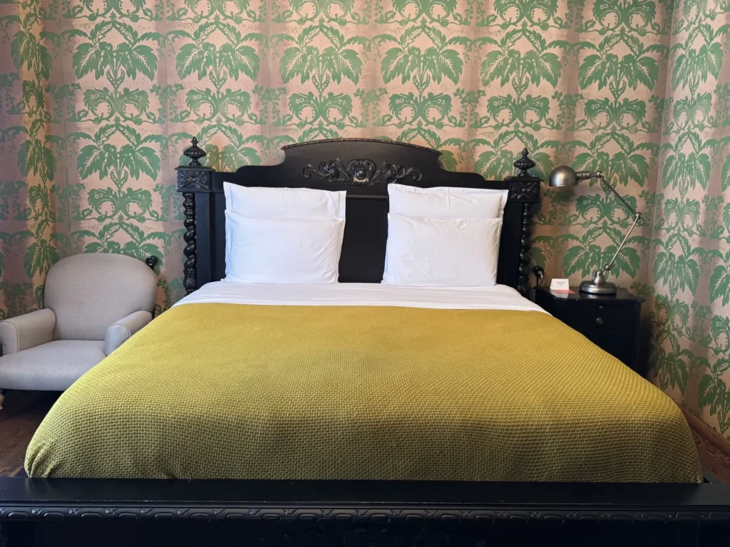 Интерьер номера в Rooms Hotel Tbilisi с винтажной мебелью и узорчатыми обоями